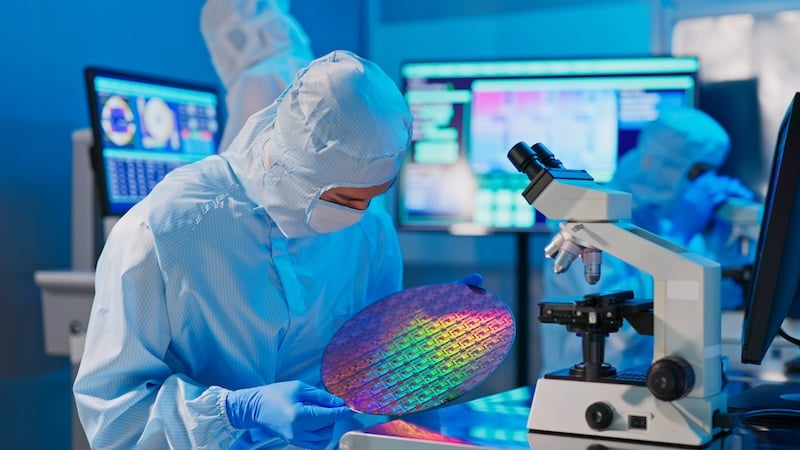 Semiconductor technician examines an integrated circuit wafer