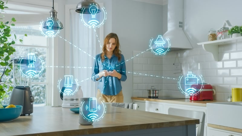Women in a kitchen demonstrates smart appliance connections to a
smartphone