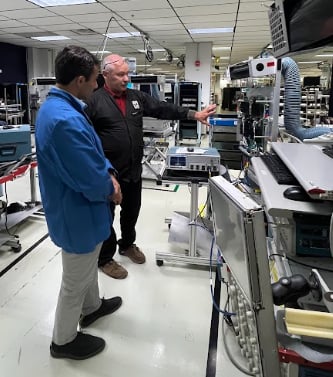 Tim Bieber (standing) demonstrates the UI on the Series 7 scope to Jake Hertz