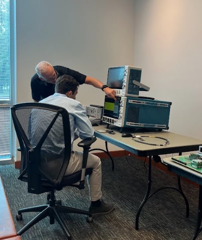 Tim Bieber (standing) demonstrates the UI on the Series 7 scope to Jake Hertz (seated)